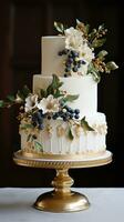 Elegant white cake with gold leaf and berries photo