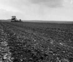 Plowed field by tractor in black soil on open countryside nature photo