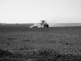 Plowed field by tractor in black soil on open countryside nature photo