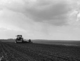 Plowed field by tractor in black soil on open countryside nature photo