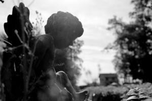 Beautiful Cupid angel statue with wings on back in vintage garden photo