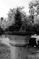 Very old sundial shows time in dense vegetation forest photo