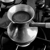 Barista preparing hot tasty drink from copper turk photo