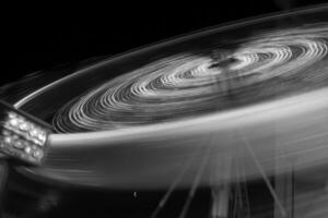 Round ferris wheel spins fast at black night photo