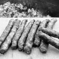 Barbecue with fiery Bavarian sausages on grill in garden outdoors photo