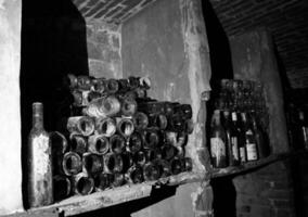 botellas de vino muy antiguas se encuentran en una bodega retro oscura foto