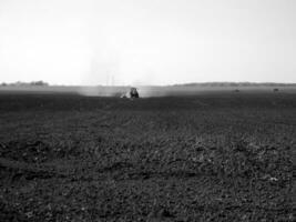 Plowed field by tractor in black soil on open countryside nature photo