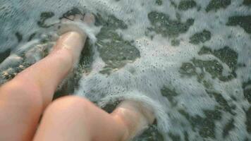 Childs feet washing with sea waves video