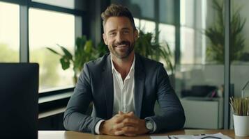 Confident professional man at office desk, smiling into the camera, bathed in daylight photo