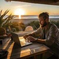 Man typing on computer at sunrise photo