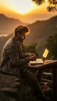 Man typing on computer at sunrise photo