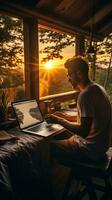 hombre mecanografía en computadora a amanecer foto