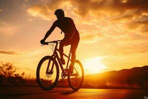 a man riding a bicycle on a road at sunset photo