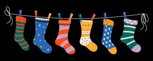 Set of colorful children socks with patterns on a rope with colored clothespins. Vector illustration