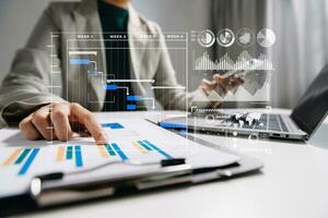 Businesswoman hand Project manager working and update tasks and Gantt chart scheduling virtual diagram.with smart phone, tablet and laptop in modern office. photo
