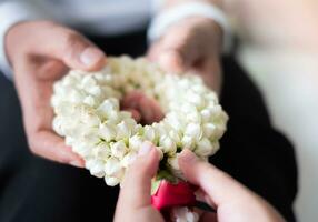 Mother's day, cute asian girl smiling and holding flower garland to give to her mother, family warmth concept, photo