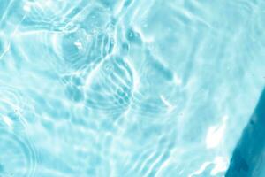 Transparent blue clear water surface texture with ripples abstract of surface blue splash and bubbles water waves reflected with sunlight photo