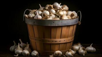 garlic in a wooden bucket on a black background photo