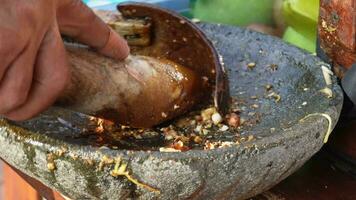 een beeldmateriaal van pinda saus is wezen gemaakt in traditioneel manier. dressing van Indonesisch fruit salade gebeld rujak video