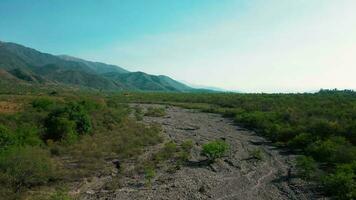 Aerial drone flying over mountains landscape with blue sky and a dry small river video