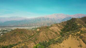 Aerial drone flying over mountains landscape with blue sky and small city video