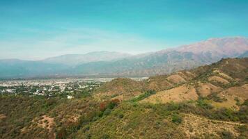 Aerial drone flying over mountains landscape with blue sky and small city video