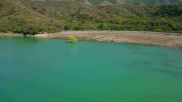 aéreo zumbido volador terminado un azul agua dique lago con montañas paisaje video