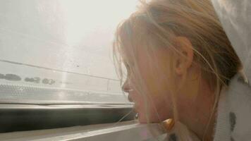 Young girl in camper van looking out window at bright sunlight video