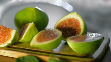 Basil leaves falling on cut green figs video