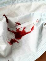 a closeup shot of a red blood on a white mask background photo