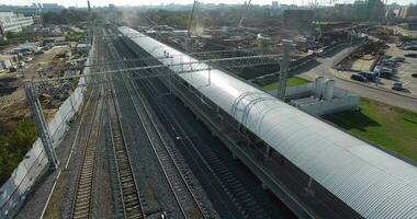 elektrisch trein aankomen naar de station in stad buitenwijken, antenne visie video