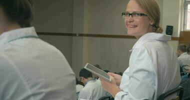 sonriente médico estudiante con almohadilla en el conferencia video