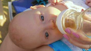 Baby Lügen auf Mütter Runde und Trinken von das Flasche video