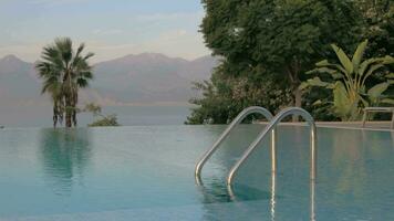 Open swimming pool in front of the mountains by the sea video