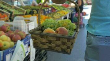 homem com cesta do uvas e pêssegos em fruta mercado video