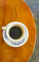 Blue white cup pot with black coffee wooden table Mexico. photo
