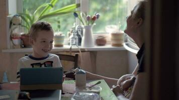 mamá jugando con hijo y enfermería bebé durante el desayuno video