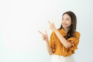 Portrait asian beautiful girl pointing blank space isolated background. Happy woman pointing on something. young female standing pointing finger sideways, billboard, introduction, advertisement, space photo