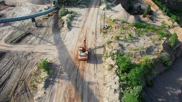 arial ver de el arena haciendo planta en a cielo abierto minería. zumbido moscas terminado excavadoras y tractor cargando aplastada Roca y rock dentro tugurio camión. 4k valores imágenes. video