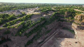 Arial view of the sand making plant in open-pit mining. Drone flies over excavators and tractor loading crushed stone and rock into dump truck. 4k stock footage. video