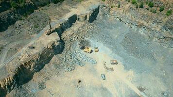 arial ver de el arena haciendo planta en a cielo abierto minería. zumbido moscas terminado excavadoras y tractor cargando aplastada Roca y rock dentro tugurio camión. 4k valores imágenes. video