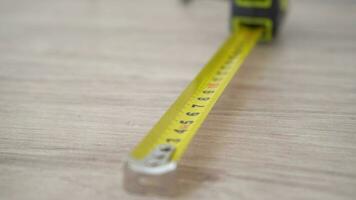 Measuring with yellow tape measure. Hands pull the measuring tape out of tape measure and measure the length. 4k stock footage. video