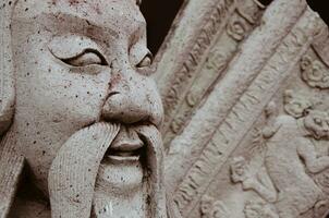 Ancient Chinese Doorguard Stone Statue Outdoor Decoration of Wat Pho Monastery at Bangkok of Thailand photo