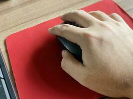 man 's hand using a laptop computer mouse photo