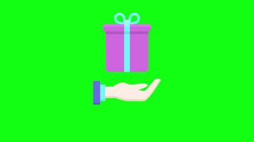 a hand holding a gift box on a green background video