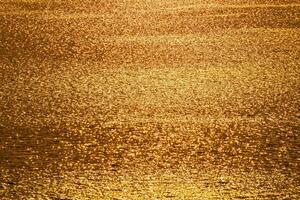 Golden sunlight reflects the ripples on the water photo