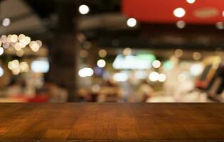 Mock up for space. Empty dark wooden table in front of abstract blurred bokeh background of restaurant . can be used for display or montage your product photo