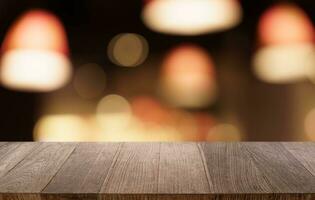 Mock up for space. Empty dark wooden table in front of abstract blurred bokeh background of restaurant . can be used for display or montage your product photo