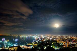 lleno Luna encima Pattaya ciudad a noche, Tailandia foto