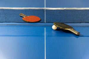 Black and red table tennis paddle with a net photo